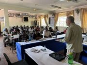Dr. Rod Getchell leads a discussion on biosecurity and fish disease for cage farmers at Ogal Beach, Kisumu County, Kenya.